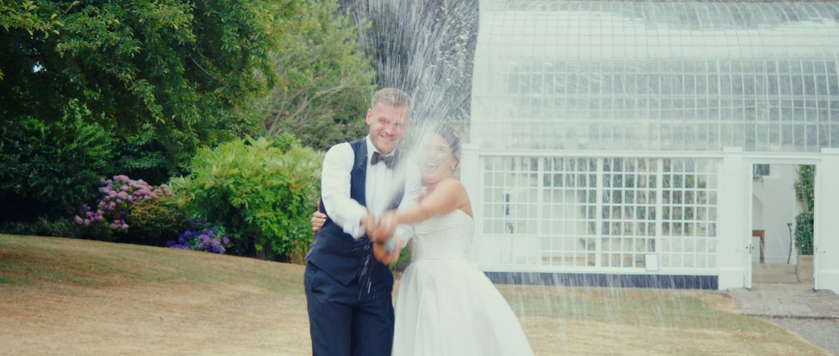 The couple spraying champagne on the lawn